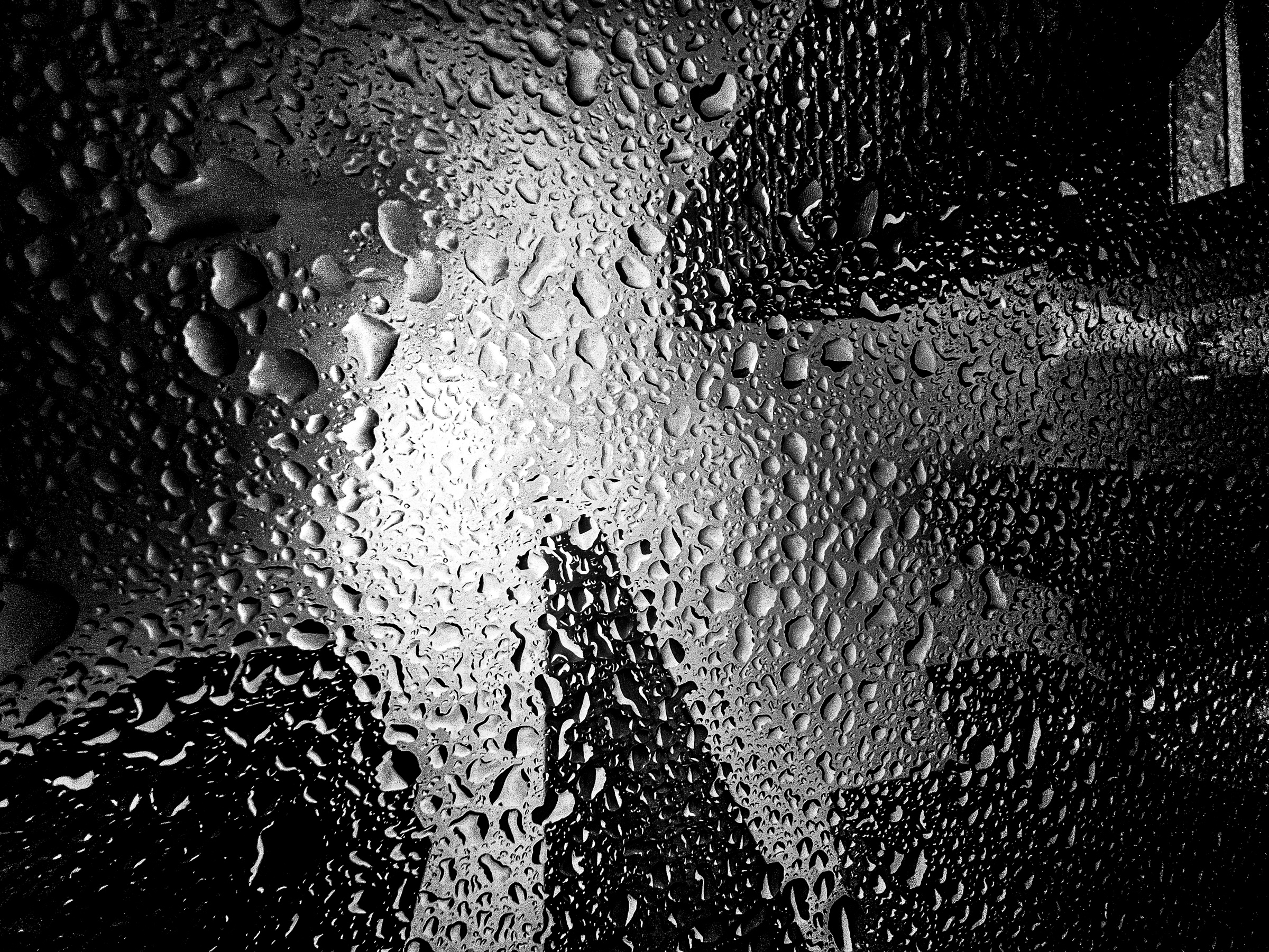 Buildings reflected in rainy sunroof