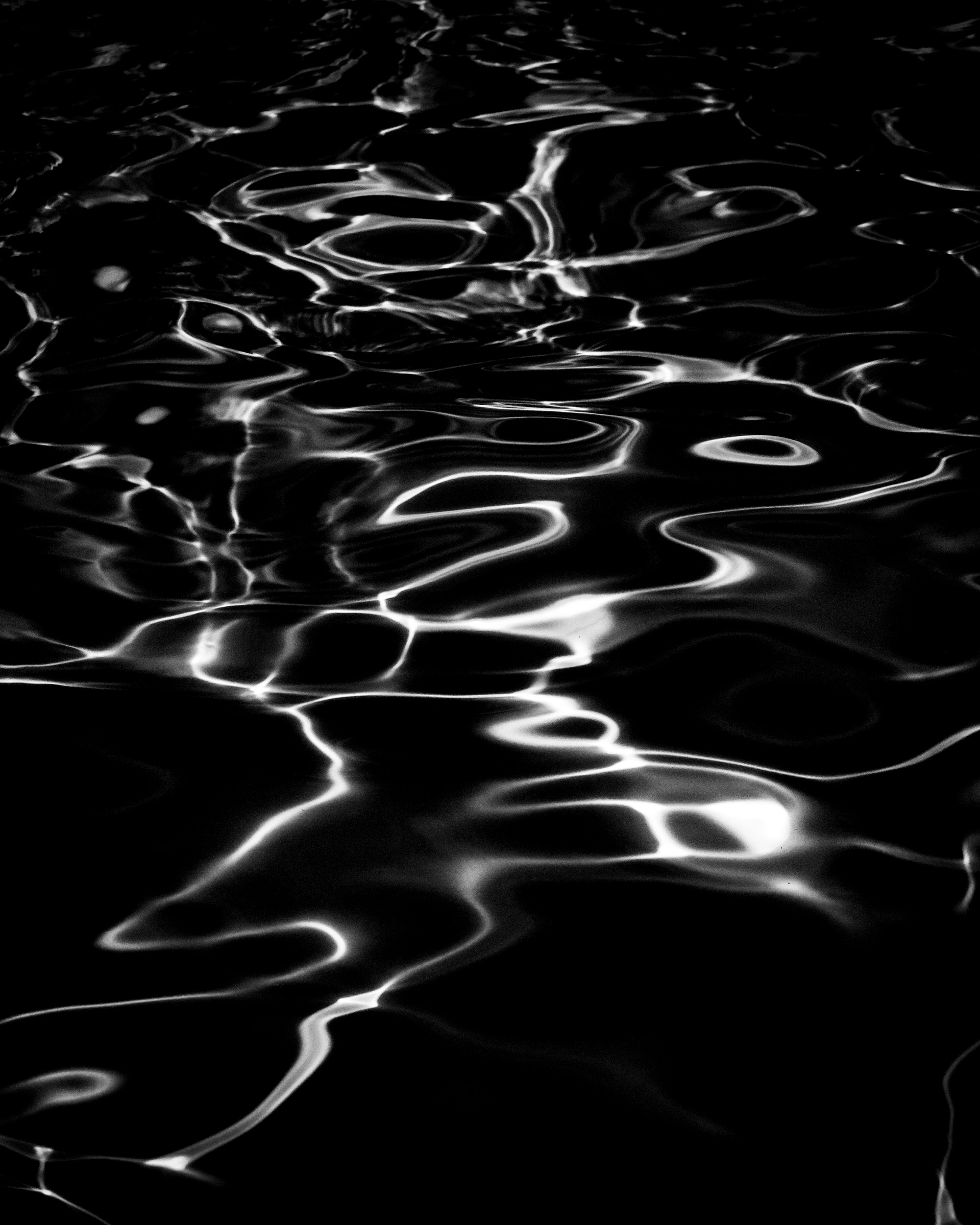 Dark water surface with glowing reflected light rings — Palm Desert, California