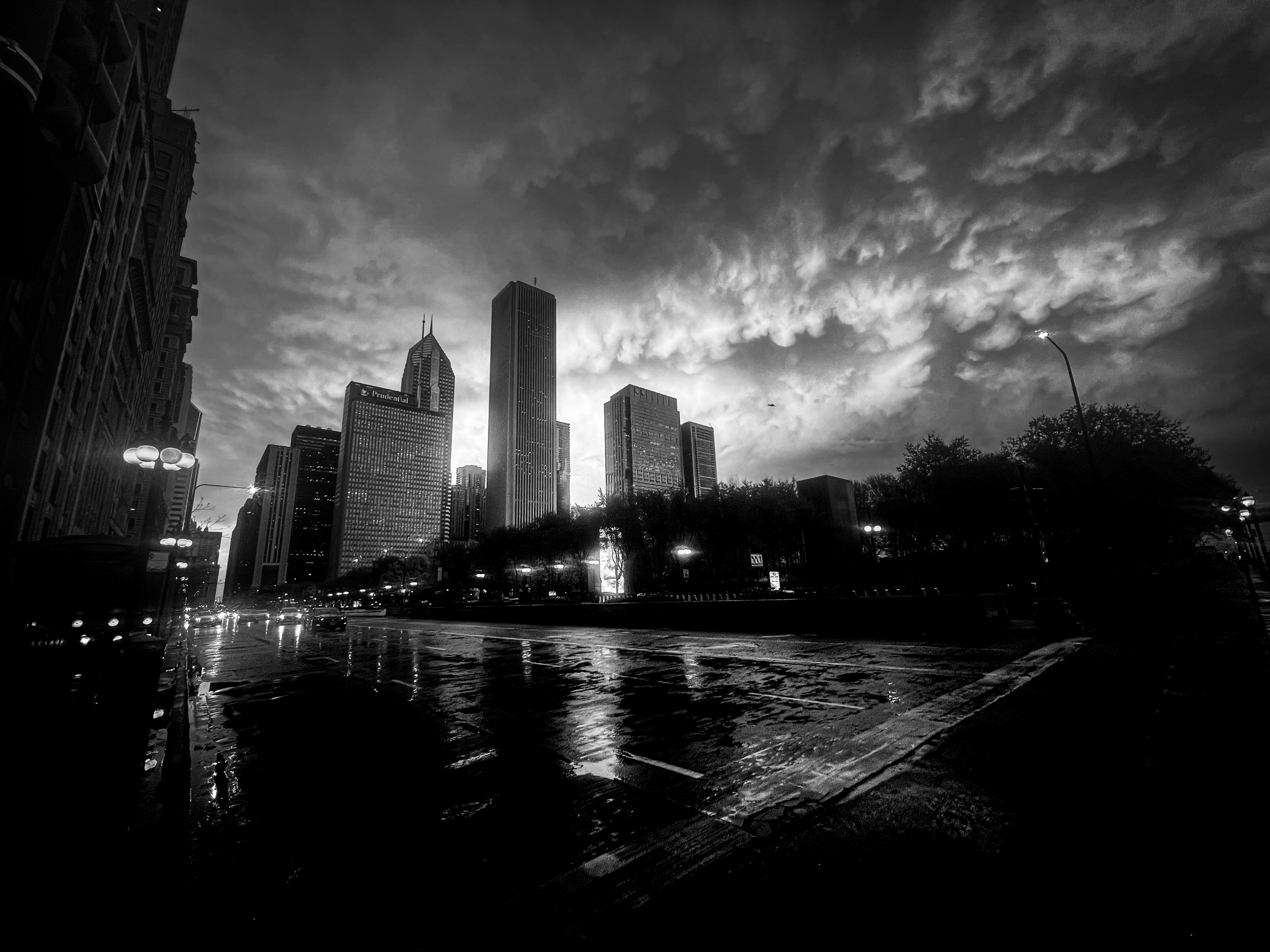 High rises against clouds wet street