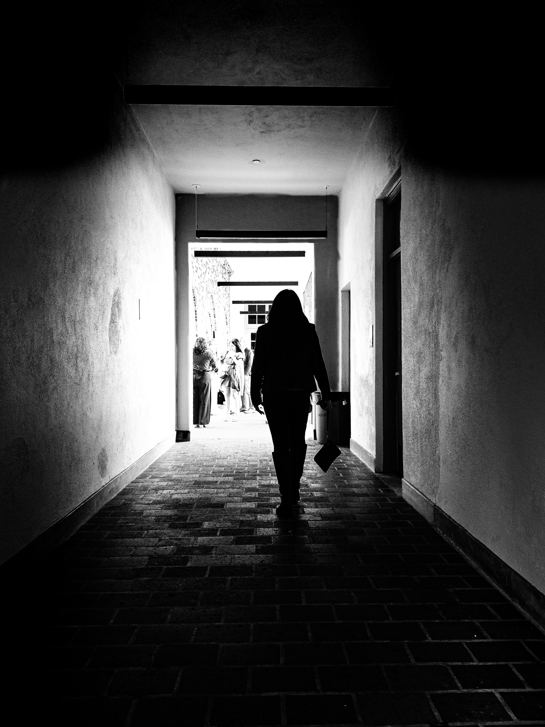 Woman walking through a corridor at Sid the Cat Auditorium — South Pasadena, California