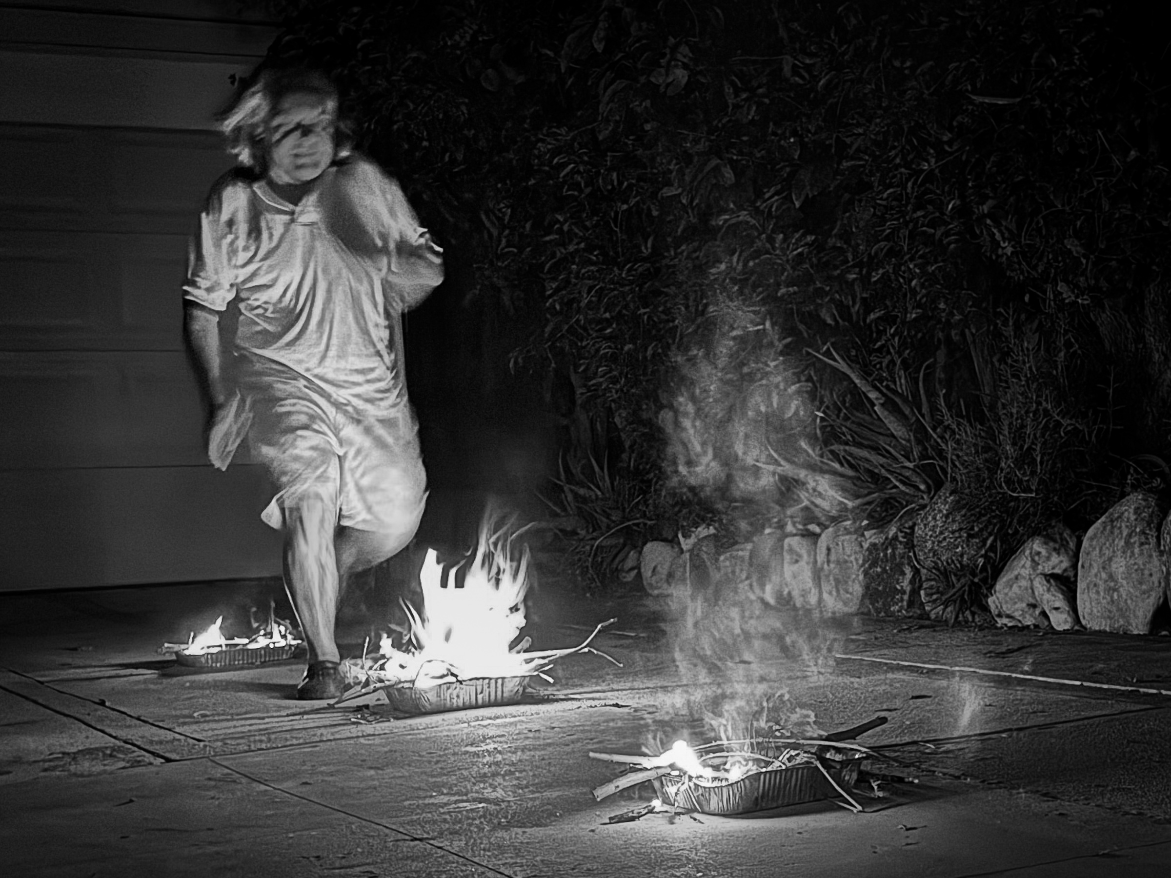Young man leaping over a Nowrouz bonfire — South Pasadena, California