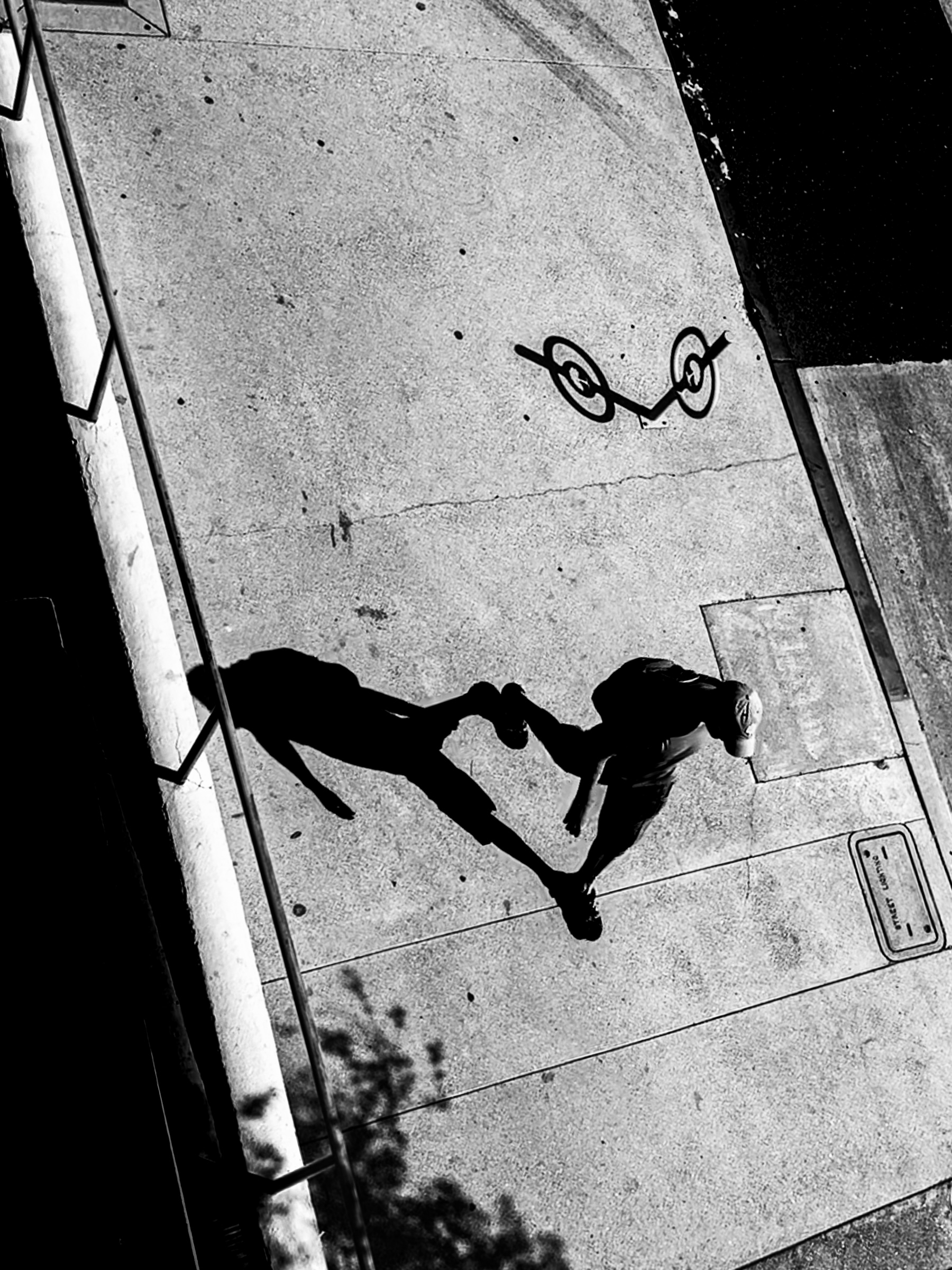 Man walking from above with bike rack shadow