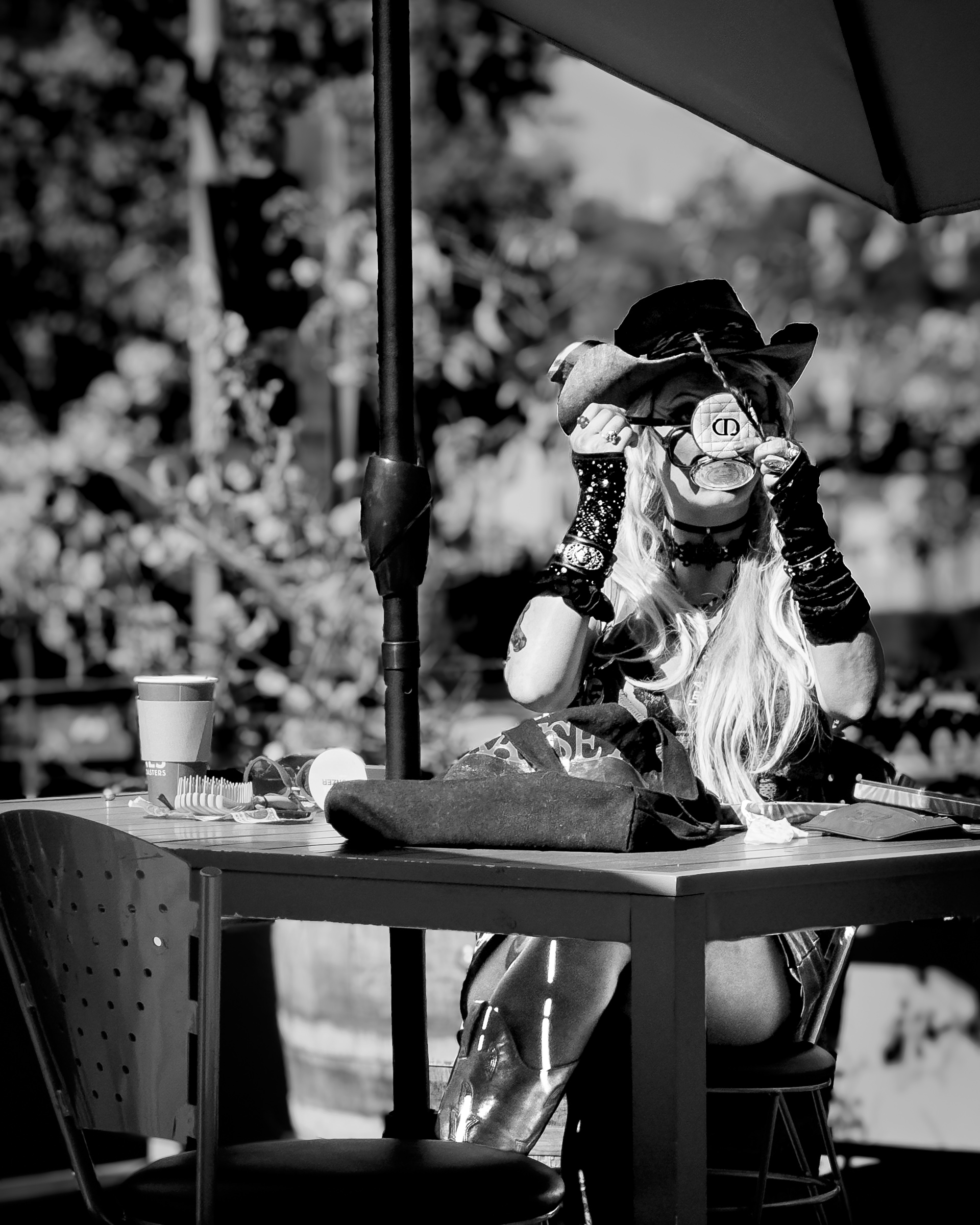 Woman putting on her makeup at Kaldis by the South Pasadena Metro — South Pasadena, California
