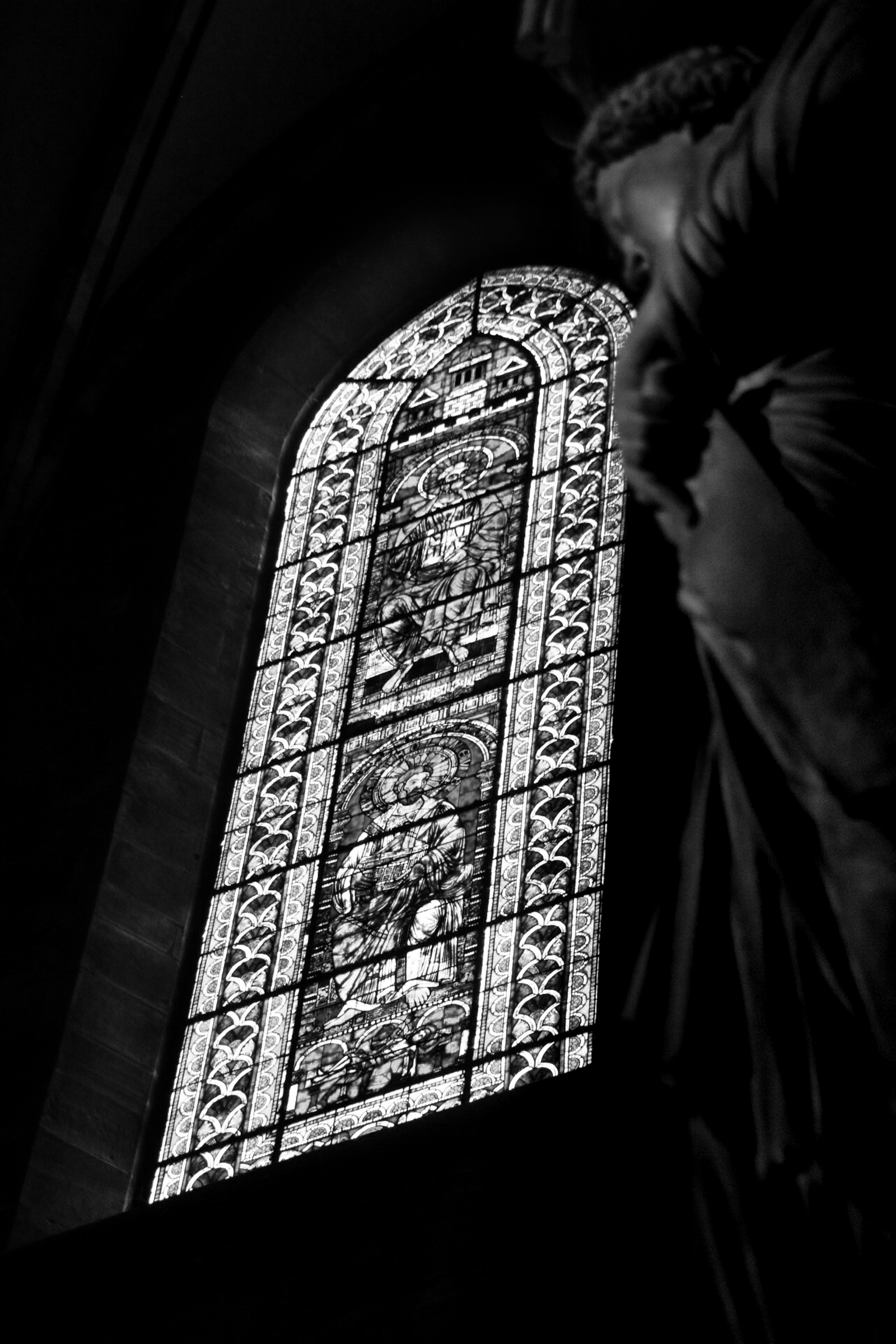 Statue with stained glass behind